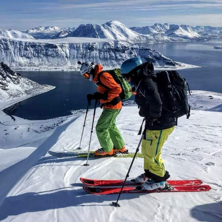 Two skiers looking over the edge of the mountain in Arnoya