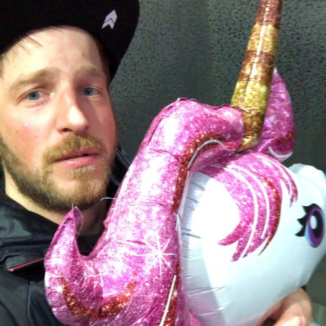 A man holding tight an inflatable unicorn