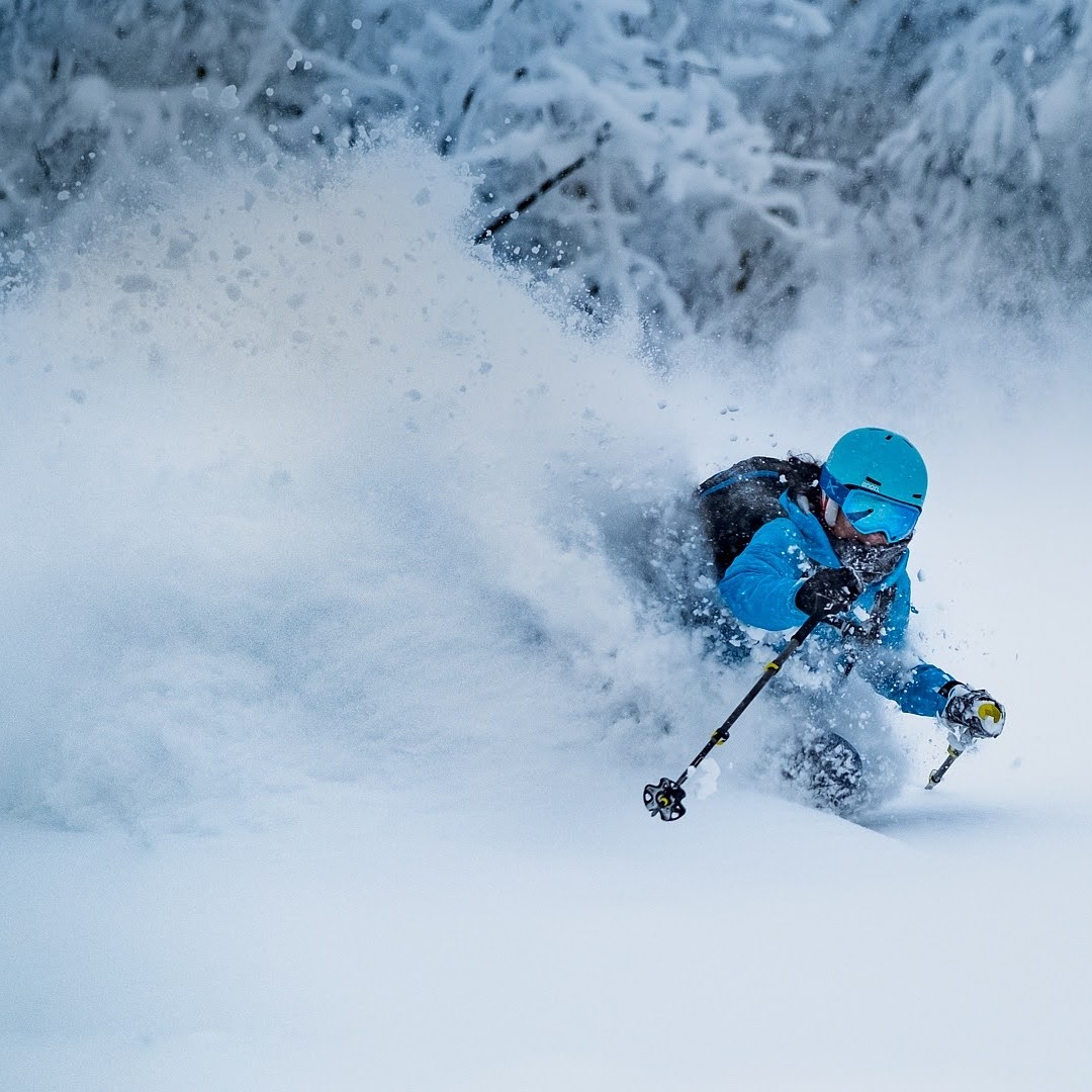 Skier making a powder turn on a ski tour