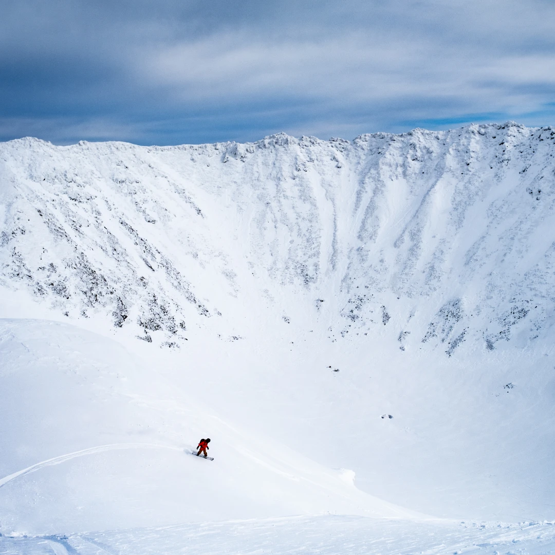 Snowboarder dropping into Mount Yotei crater